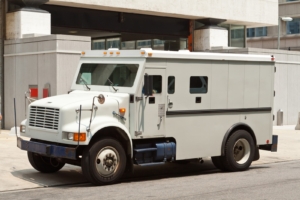 Side view of gray armored truck parked on street